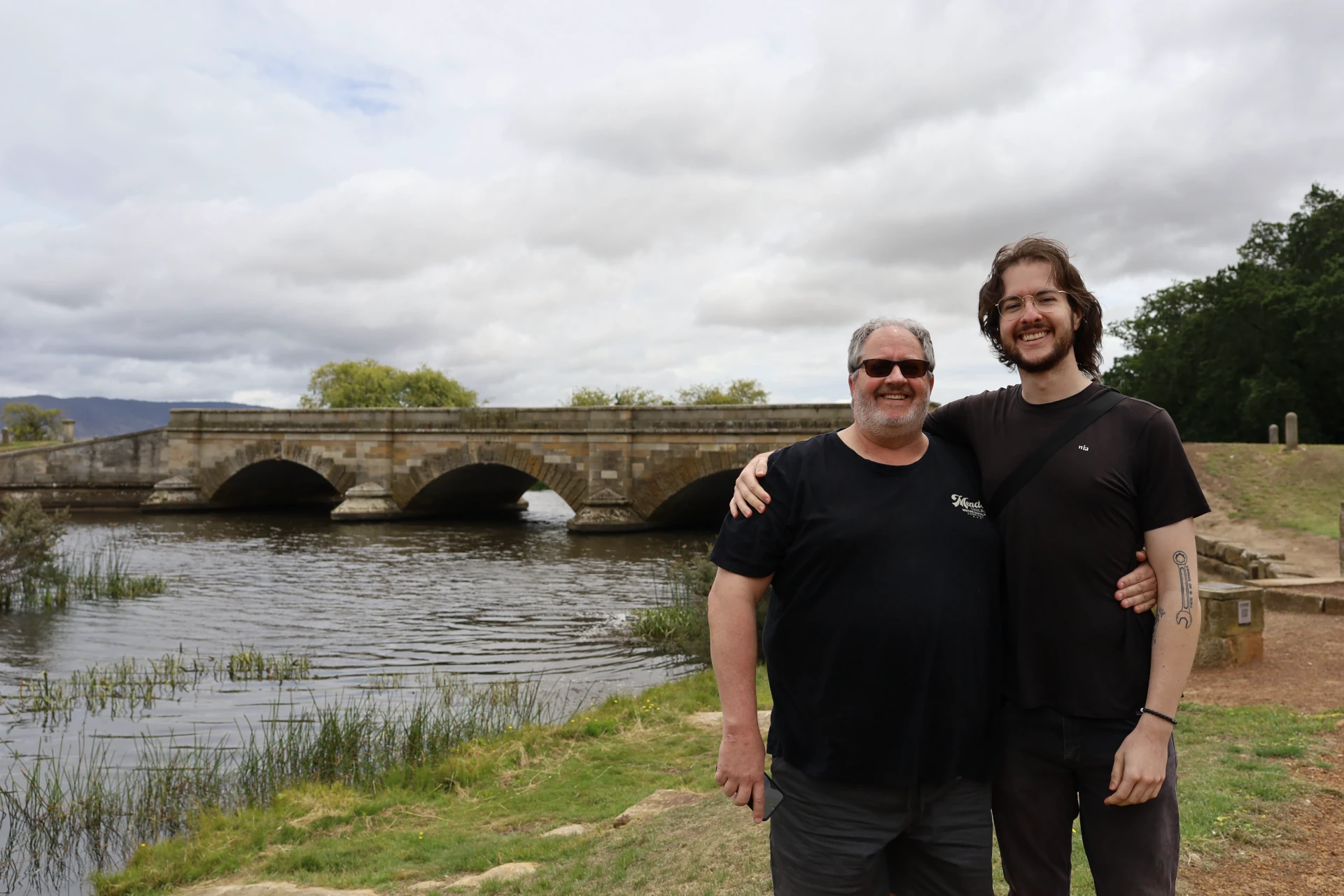 Steve and Aaron standing in front of a bridge, out in the cold